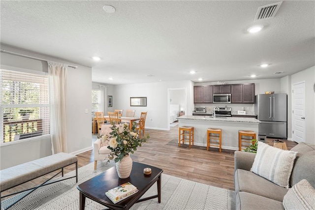 10232 Brodick Loop, Spanish Fort, AL 36527 - living room with light wood-style floors, recessed lighting, baseboards, and a textured ceiling
