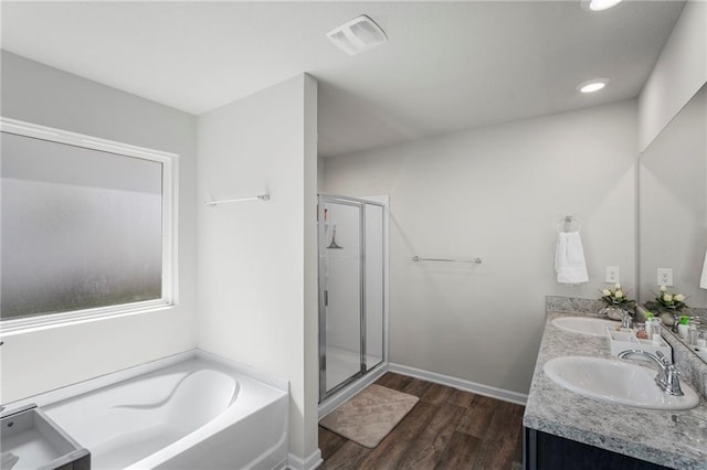 10232 Brodick Loop, Spanish Fort, AL 36527 - full bathroom featuring a bath, a stall shower, double vanity, wood finished floors, and recessed lighting