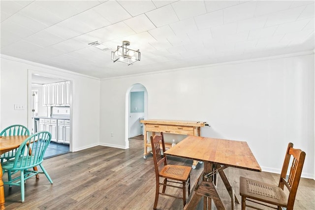 dining room with crown molding and dark hardwood / wood-style floors