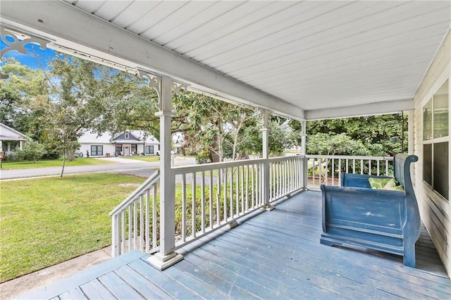 wooden deck with covered porch and a lawn