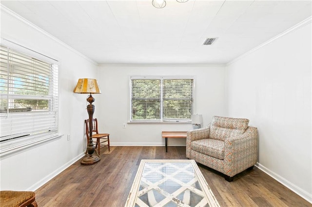 living area with crown molding, hardwood / wood-style floors, and plenty of natural light