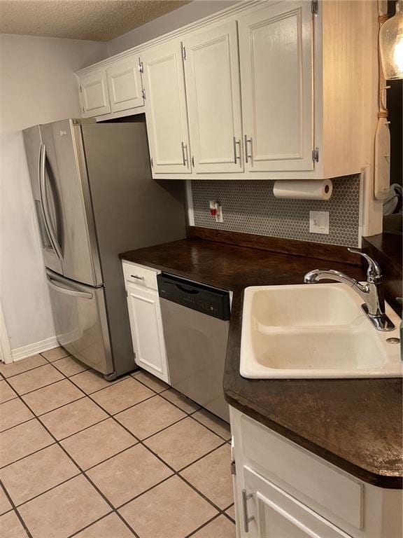 kitchen with white cabinets, appliances with stainless steel finishes, a textured ceiling, and sink