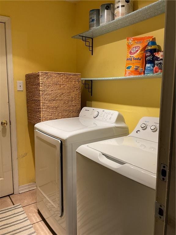 clothes washing area featuring washing machine and clothes dryer and light tile patterned flooring