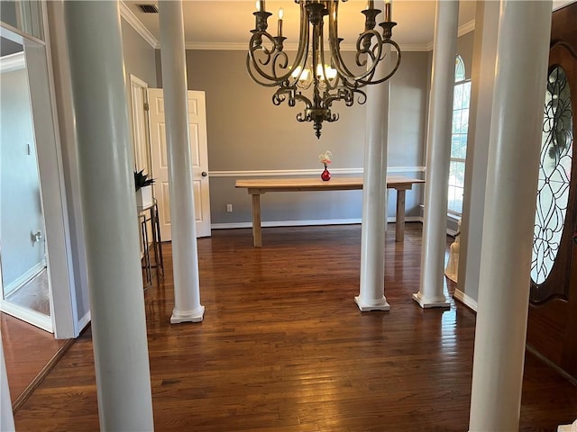 dining area with ornate columns, crown molding, dark wood-type flooring, and a notable chandelier