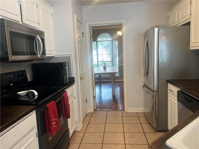 kitchen with light tile patterned flooring, white cabinetry, stainless steel appliances, and tasteful backsplash