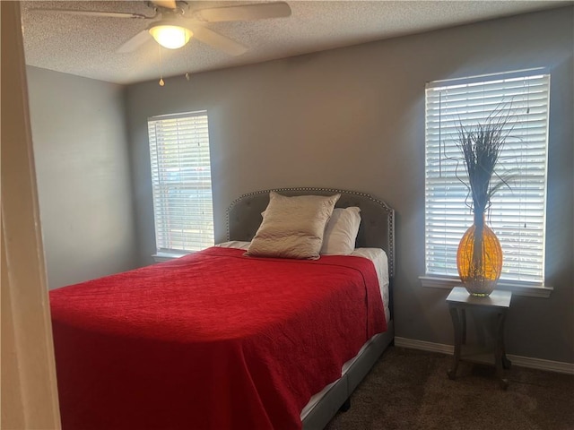 carpeted bedroom with ceiling fan, a textured ceiling, and multiple windows