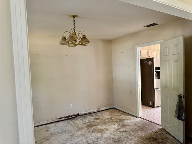 spare room featuring concrete flooring, baseboards, visible vents, and a notable chandelier