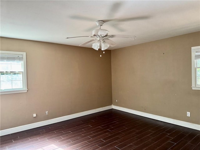 spare room featuring a healthy amount of sunlight, ceiling fan, baseboards, and wood finished floors