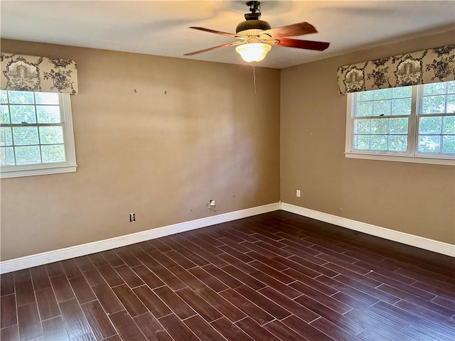 unfurnished room with dark wood-style flooring, ceiling fan, and baseboards