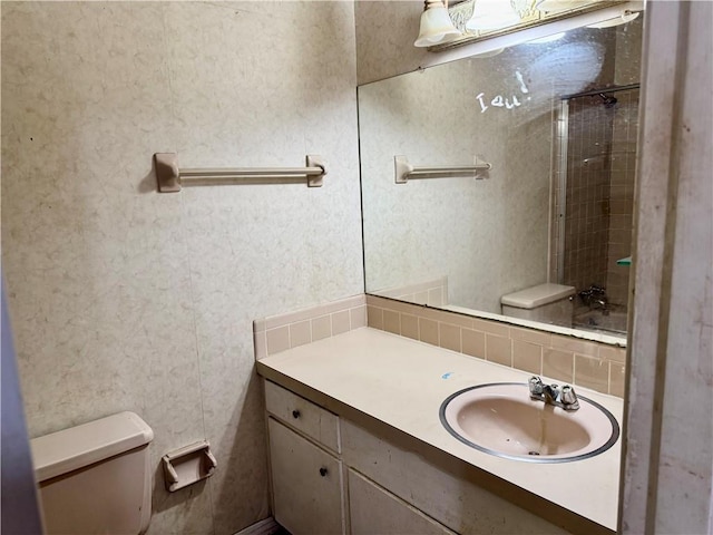 bathroom with a shower, vanity, and toilet