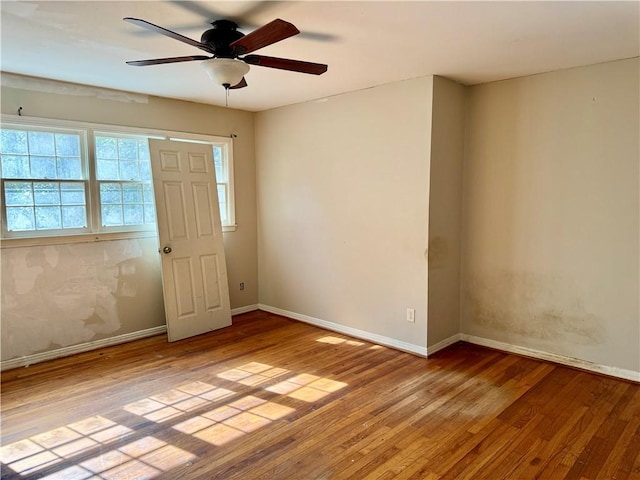 empty room with ceiling fan, wood-type flooring, and baseboards