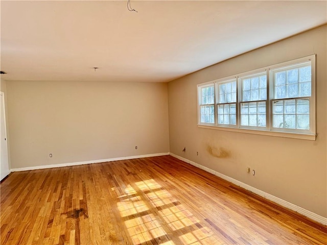 spare room featuring light wood-style floors and baseboards