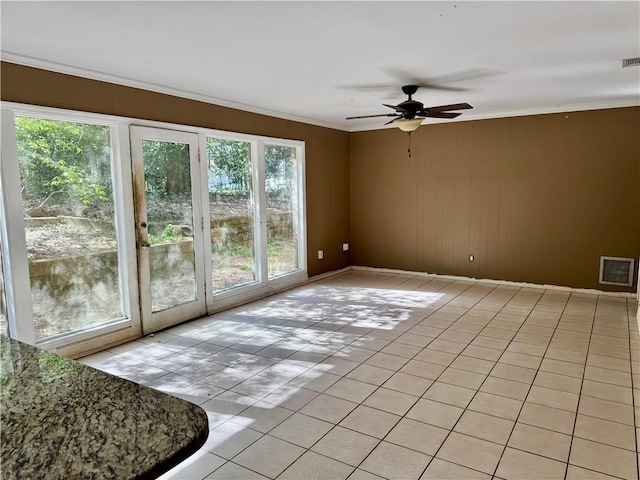 spare room with ornamental molding, light tile patterned flooring, visible vents, and a ceiling fan