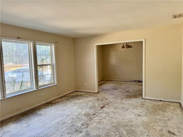 empty room featuring baseboards and visible vents