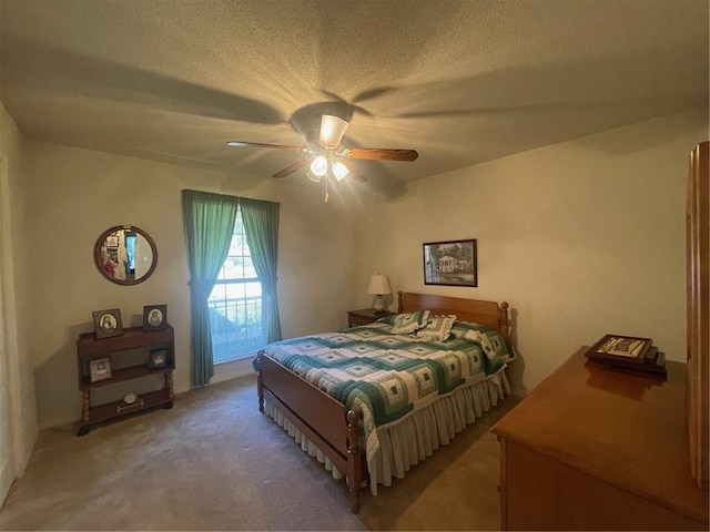 carpeted bedroom featuring ceiling fan and a textured ceiling