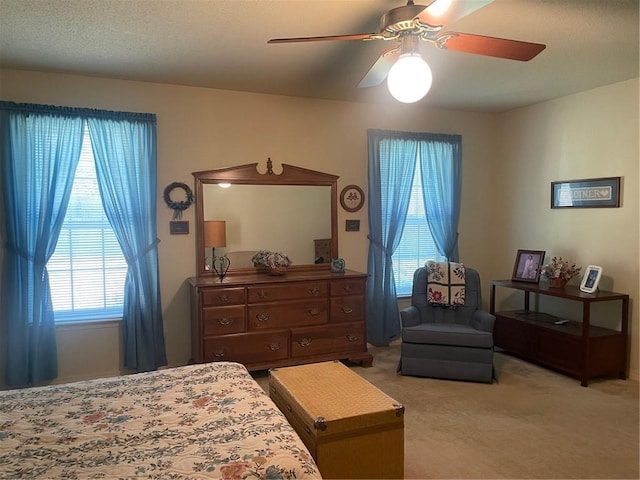 bedroom featuring light carpet and a ceiling fan