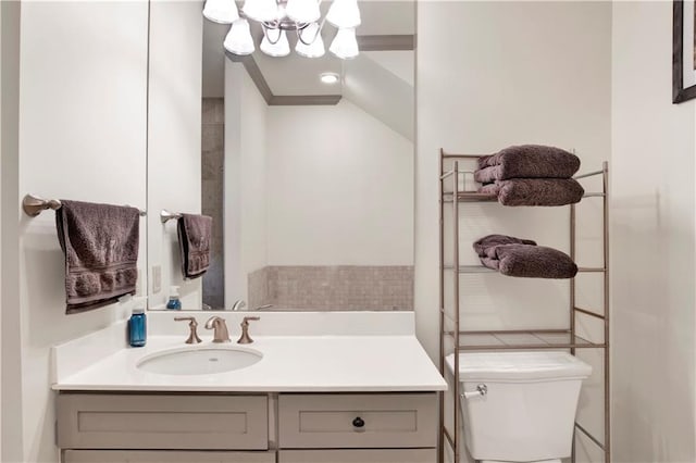 bathroom with an inviting chandelier, vanity, and toilet