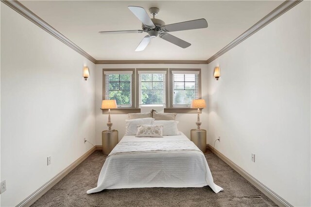 carpeted bedroom featuring ceiling fan and crown molding