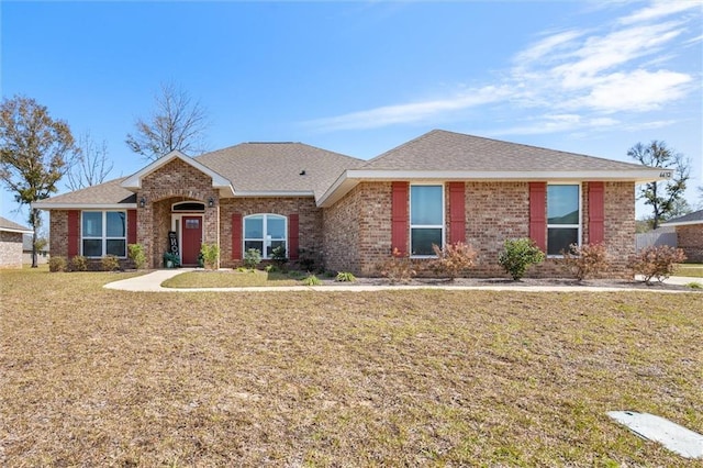 single story home with brick siding, a shingled roof, and a front lawn