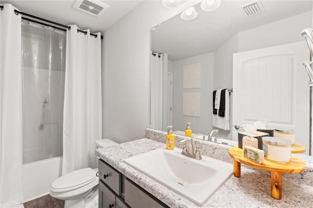 bathroom with visible vents, toilet, vanity, and shower / bath combination with curtain