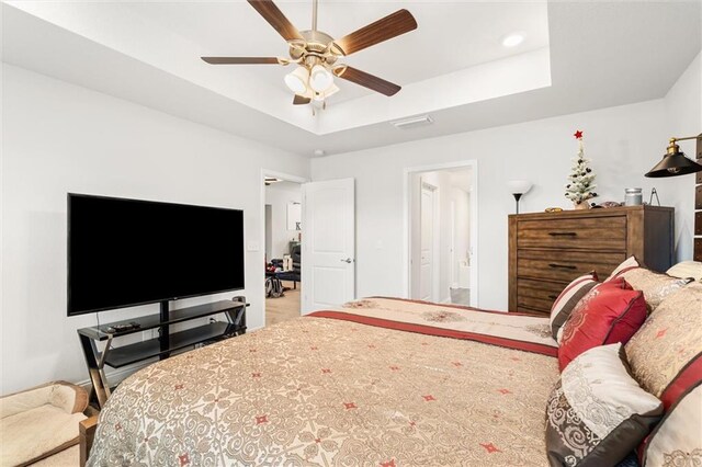 bedroom with a raised ceiling and a ceiling fan