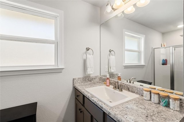 bathroom featuring a shower stall and vanity