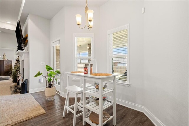 dining area with baseboards, an inviting chandelier, and dark wood-style flooring