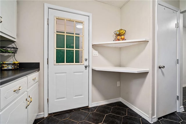 7072 Forest Glenn Ct, Irvington, AL 36544 - doorway to outside featuring baseboards and dark tile patterned floors