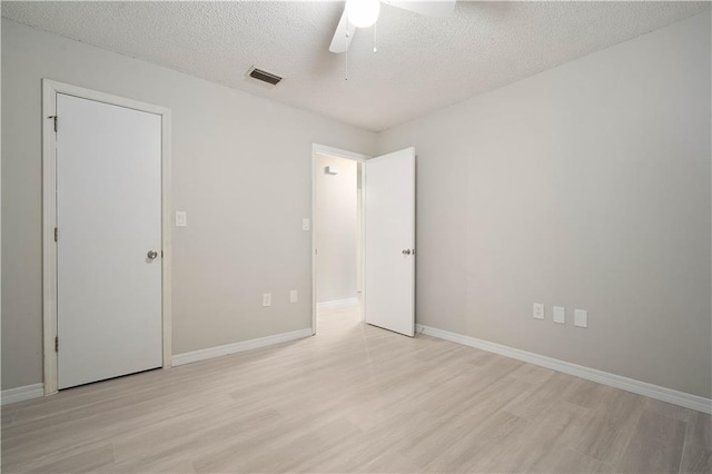 7072 Forest Glenn Ct, Irvington, AL 36544 - unfurnished bedroom with light wood-type flooring, a textured ceiling, and a ceiling fan