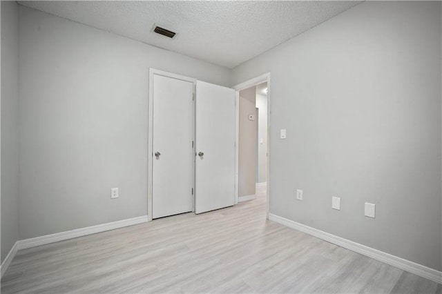 7072 Forest Glenn Ct, Irvington, AL 36544 - unfurnished bedroom with light wood-style flooring and a textured ceiling