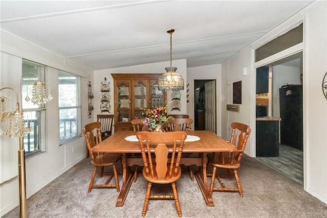 dining room featuring lofted ceiling, carpet flooring, and plenty of natural light