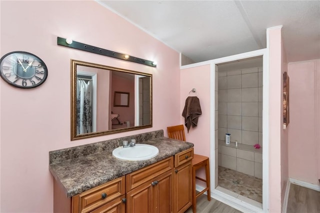 bathroom featuring vanity, hardwood / wood-style floors, and a tile shower