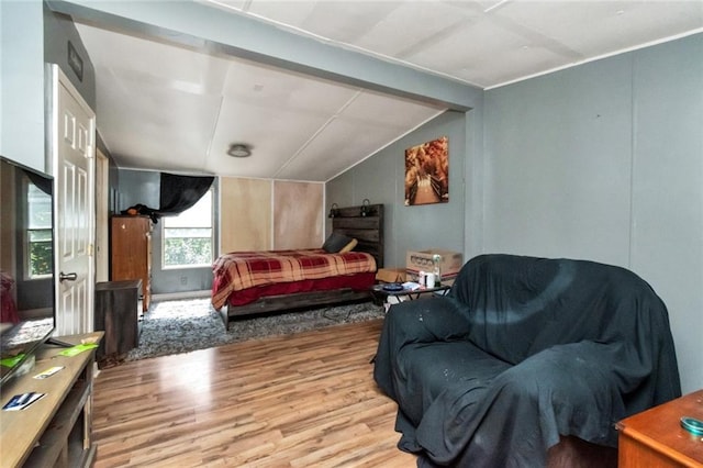 bedroom with lofted ceiling and light wood-type flooring