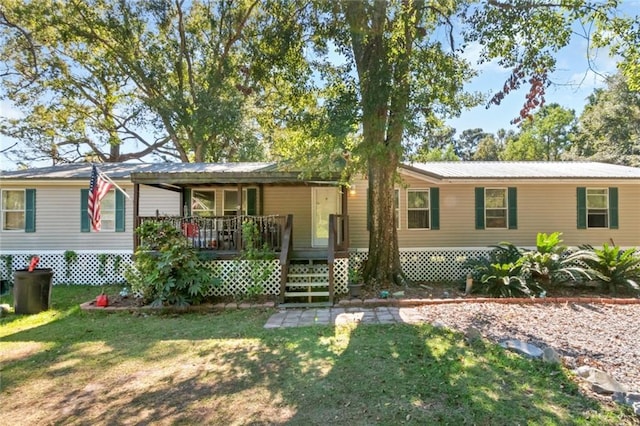 manufactured / mobile home featuring a front yard and a deck