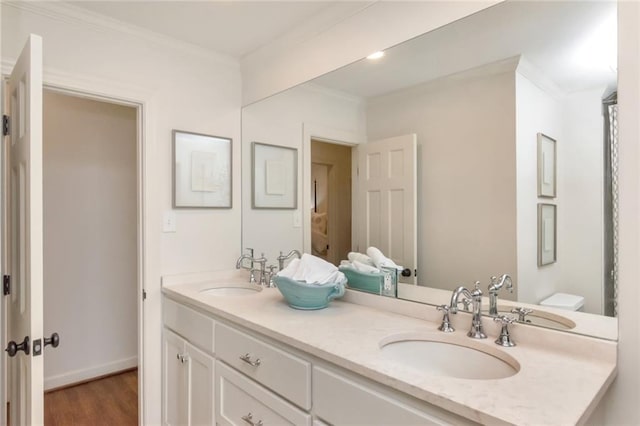 bathroom featuring hardwood / wood-style flooring, ornamental molding, and vanity