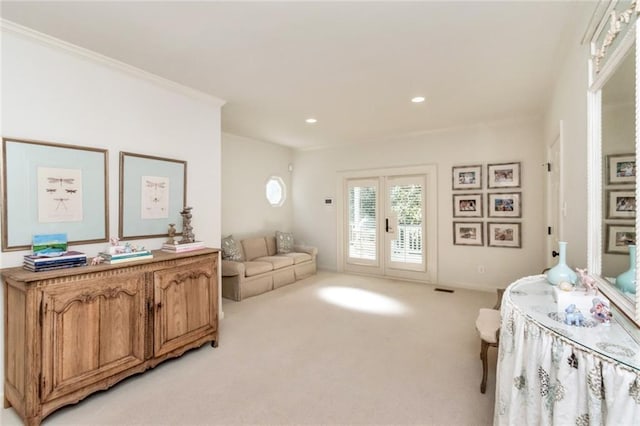 sitting room featuring light colored carpet and ornamental molding