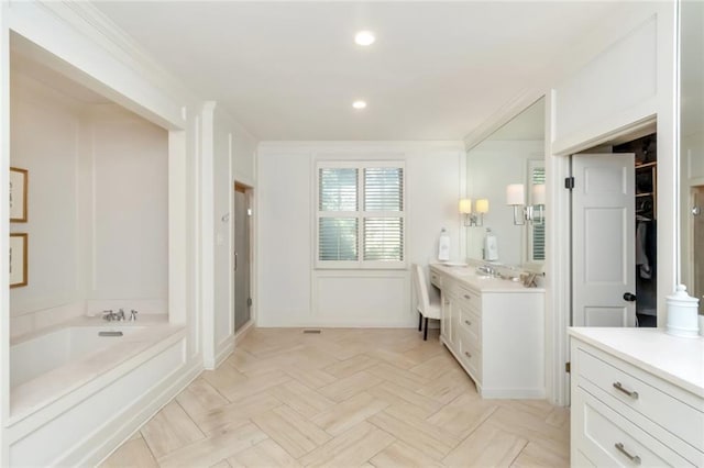 bathroom featuring ornamental molding, vanity, and a bath