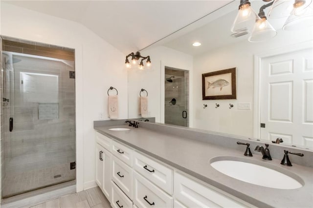 bathroom with an enclosed shower, hardwood / wood-style flooring, an inviting chandelier, lofted ceiling, and vanity