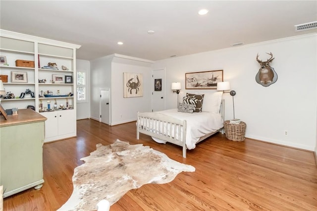 bedroom with ornamental molding and hardwood / wood-style floors