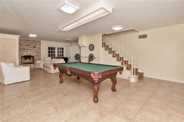 recreation room featuring pool table, light tile patterned floors, and a brick fireplace