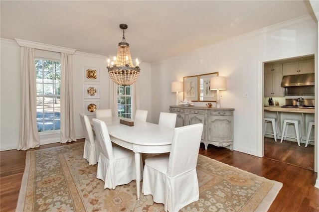 dining area with crown molding, dark hardwood / wood-style floors, sink, and a chandelier