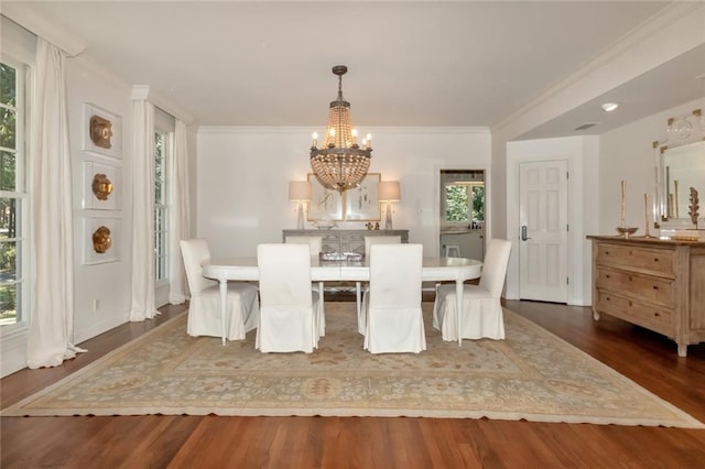 dining room featuring crown molding, dark wood-type flooring, and a chandelier