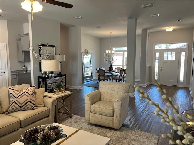 living room featuring ceiling fan with notable chandelier, plenty of natural light, and dark hardwood / wood-style floors