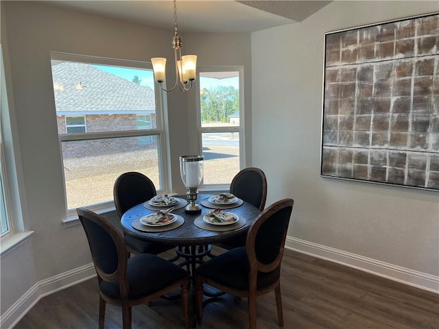 dining space with dark wood-type flooring and a chandelier