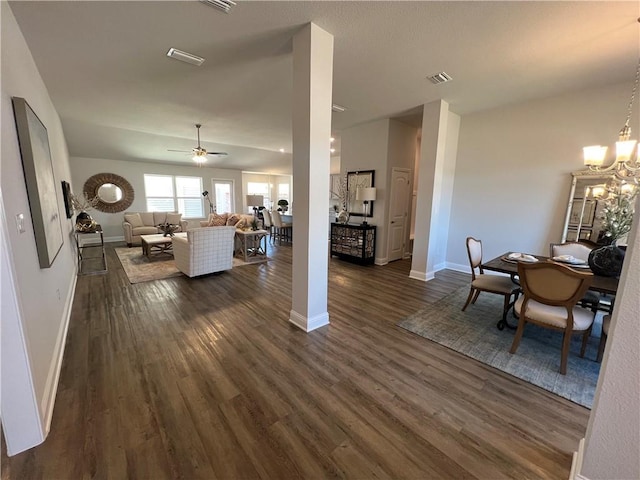 living room featuring dark wood-type flooring and ceiling fan with notable chandelier