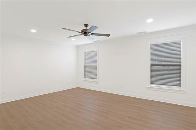 empty room with ceiling fan and light hardwood / wood-style floors