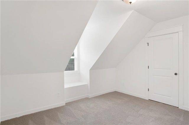 additional living space with vaulted ceiling and light carpet