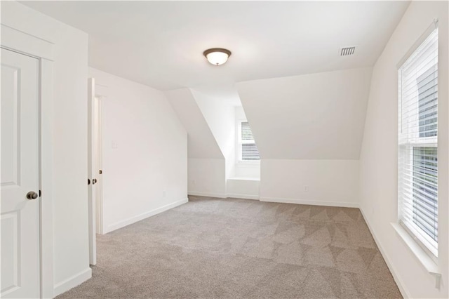 bonus room featuring plenty of natural light, light carpet, and lofted ceiling