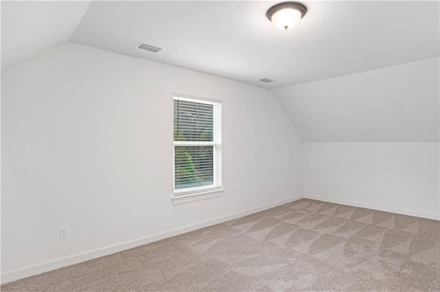 bonus room featuring light carpet and vaulted ceiling