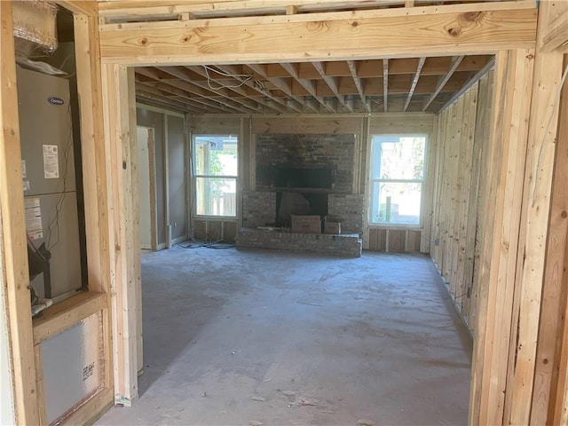 misc room featuring a fireplace, concrete floors, and heating unit